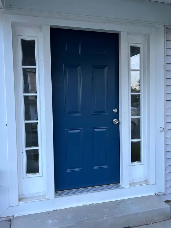 New navy six-panel front door with brushed nickel hardware between two sidelights