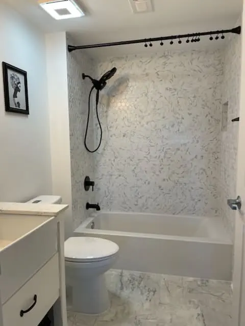 Bathroom with a hex mosaic tub surround and matte black shower fixtures