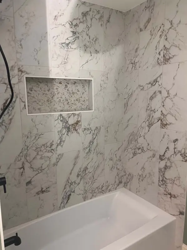 Calacatta marble-look tub surround with a hex mosaic niche